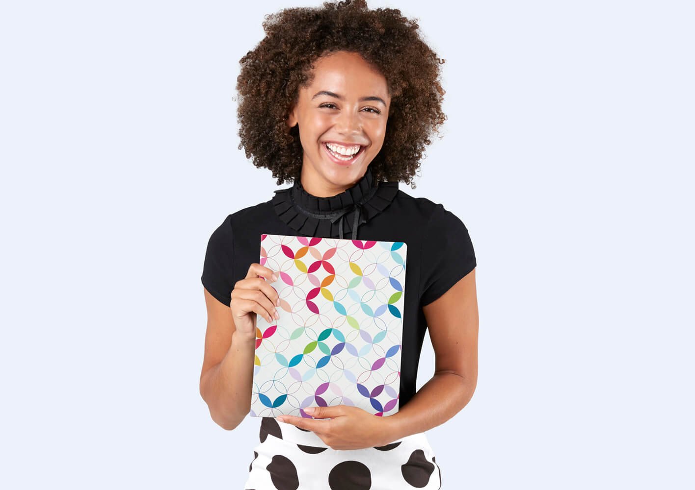 Woman holding Softbound Planners and looking at you.